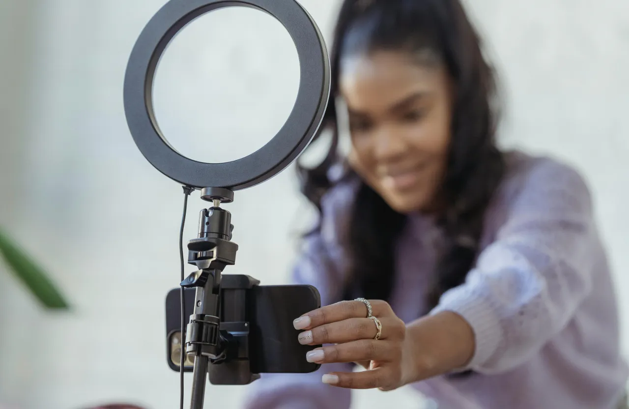 a woman holding a camera in front of a mirror