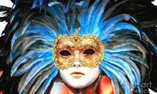 a woman wearing a mask with feathers on her head