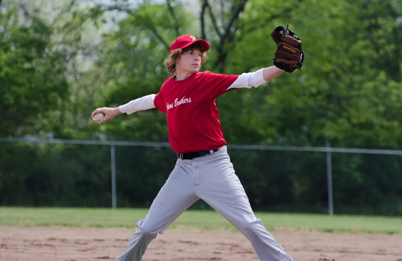 a young man pitching a baseball on top of a pitching mound