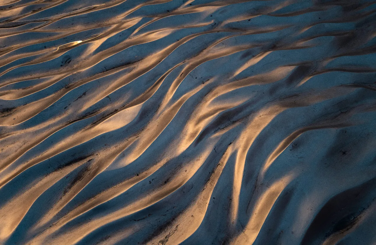 a sandy beach covered in waves of sand