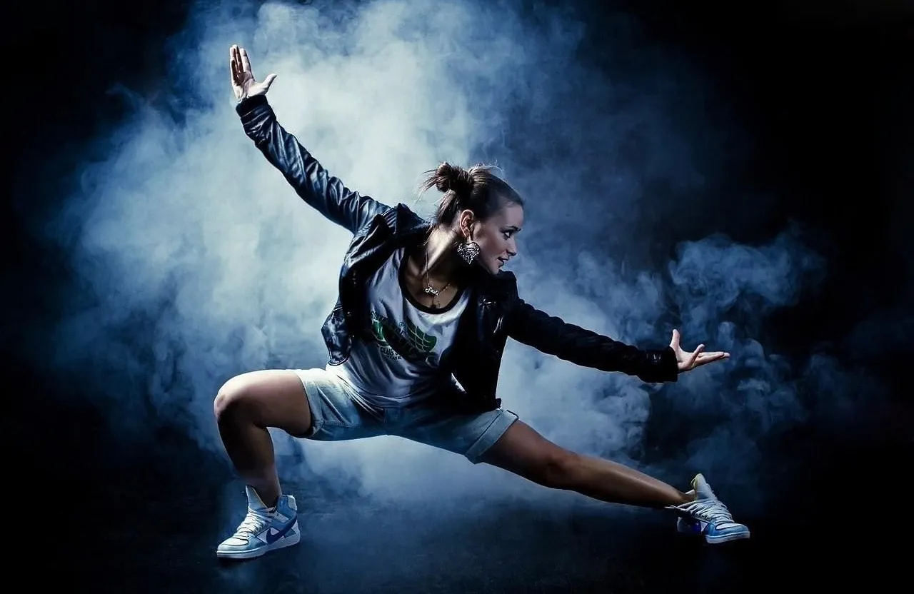 a woman in a black jacket is dancing