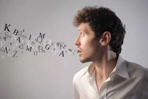 a man standing in front of a wall with letters written on it