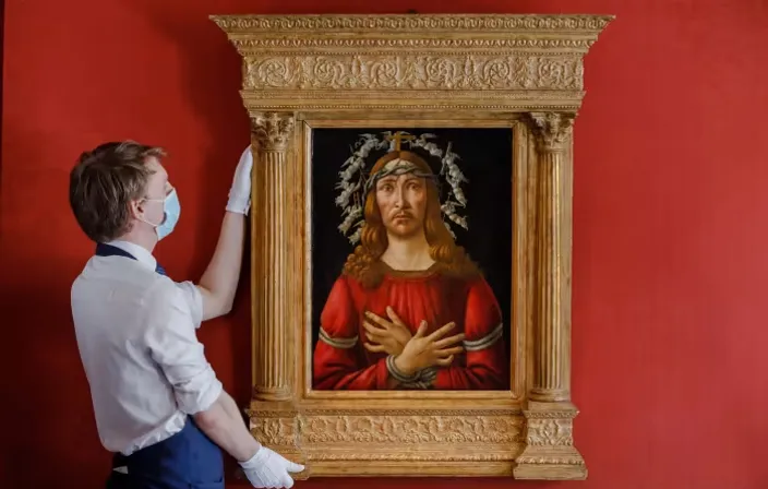 a man in a white shirt is painting a picture on a red wall