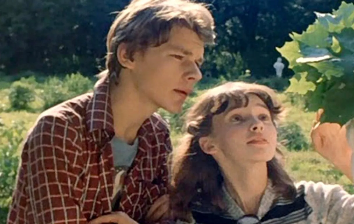 a man and a woman looking at a plant