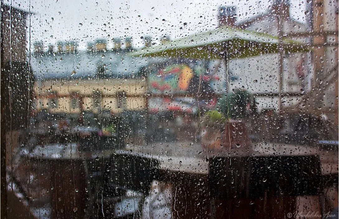 A window partially submerged in water, sunlight piercing through the liquid and creating rich colors and patterns