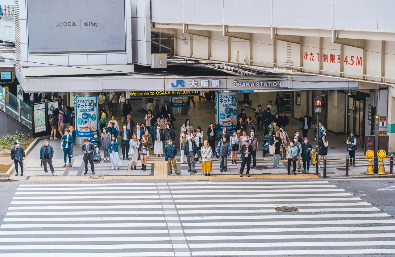 a group of people standing in front of a building in Osaka Japan