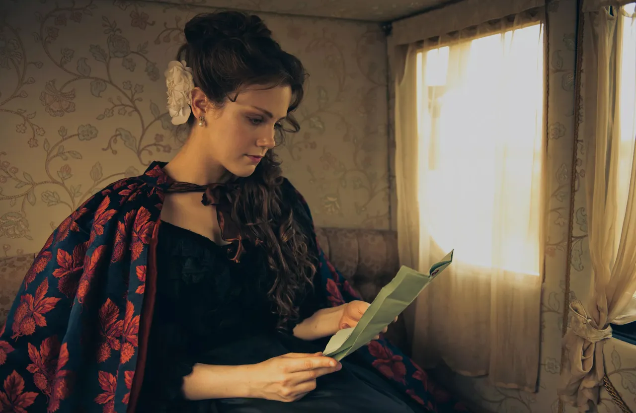 a woman sitting on a couch reading a book