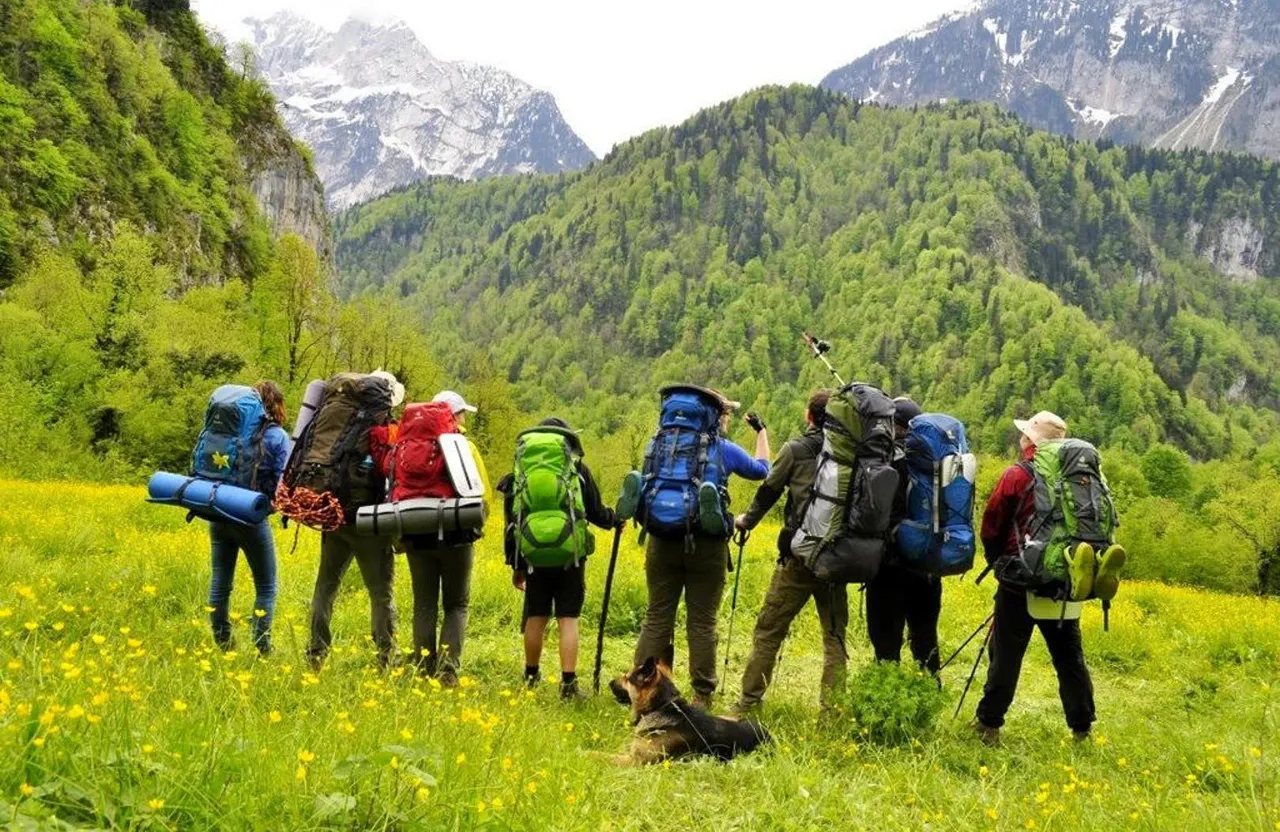 a group of people with backpacks standing in a field