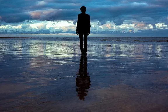 a person standing on a beach looking out at the ocean