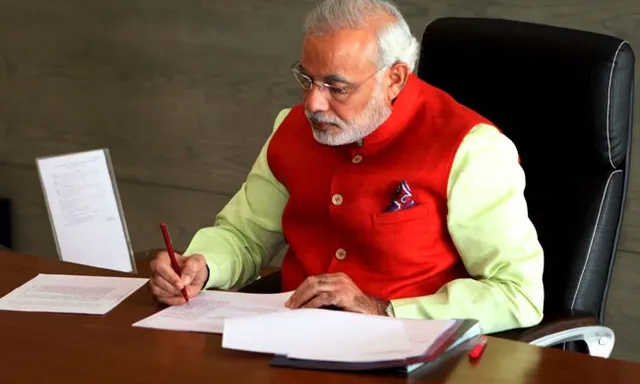 a man sitting at a desk with papers and a pen