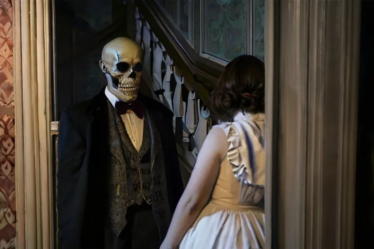 a skeleton dressed in a suit and bow tie standing next to a woman in a