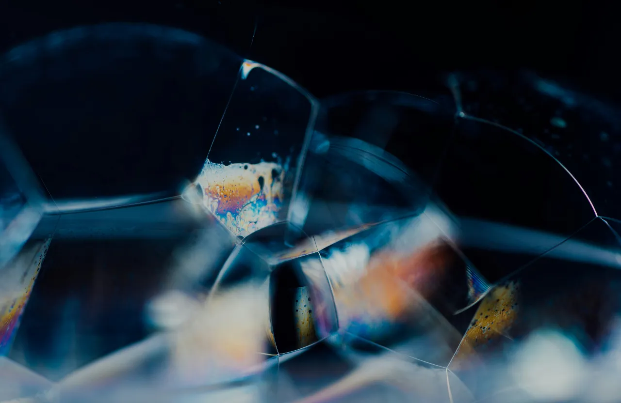 A macro shot of a glass object, with bokeh-effect lights in background