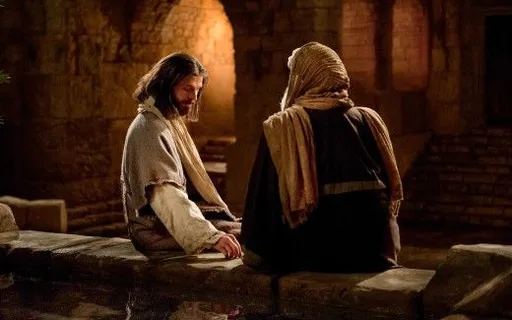 a man sitting next to a man on a stone wall