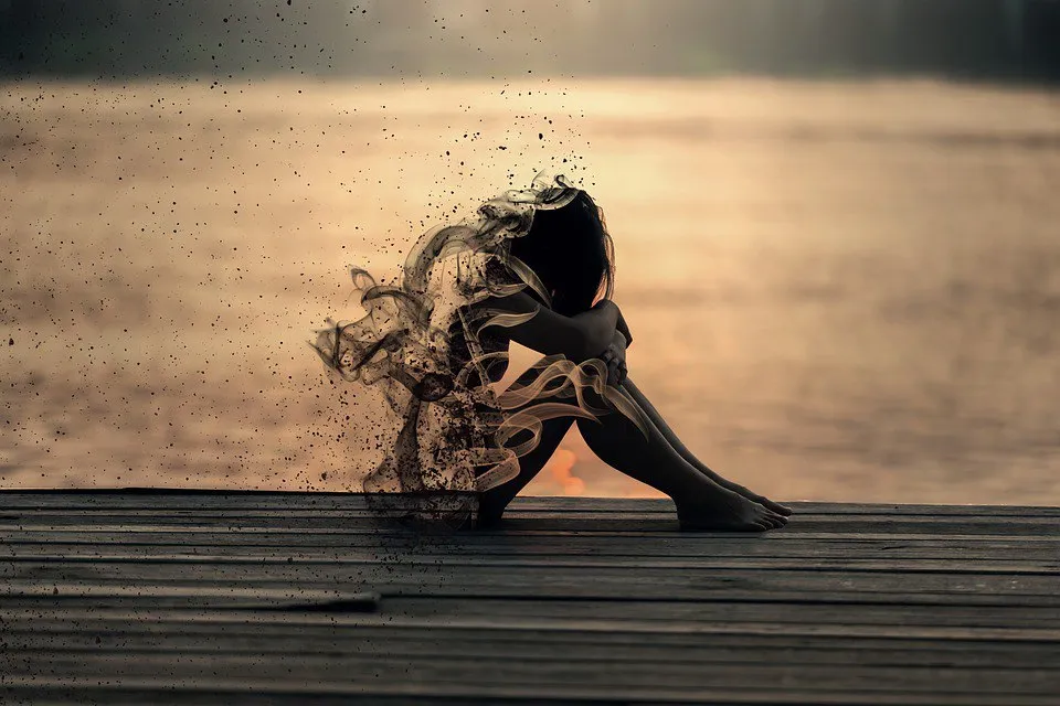 a person sitting on a dock with a body of water in the background