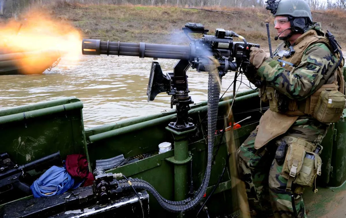 a man in military gear shooting a machine gun