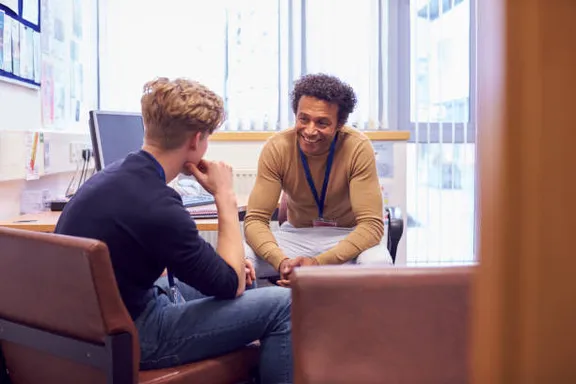 two men sitting at a table and drink juice