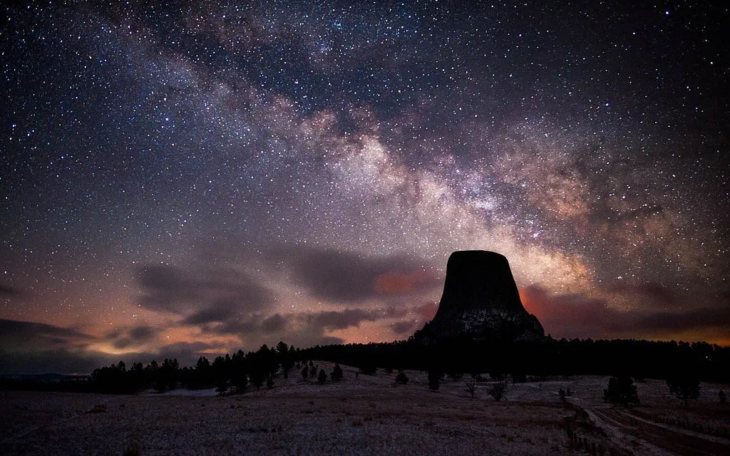 the night sky is filled with stars above a mountain