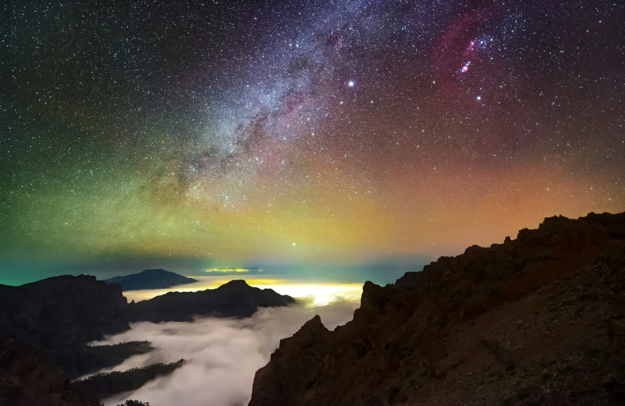 a view of the night sky with clouds and stars