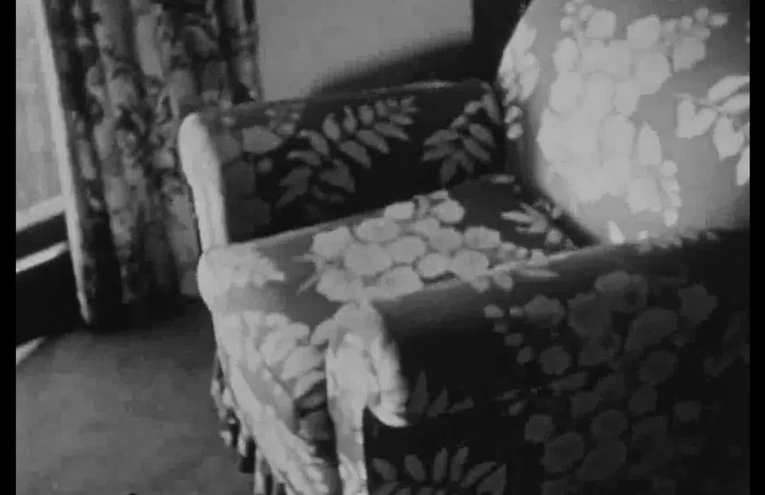 a black and white photo of a chair in a living room