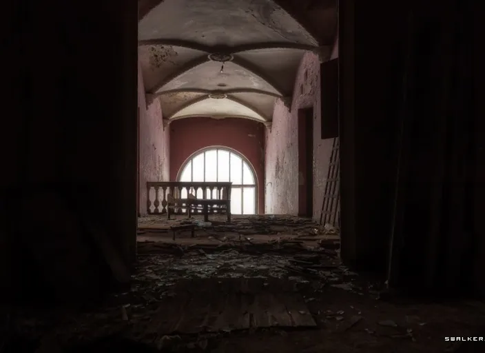 a dark hallway with a round window in the center