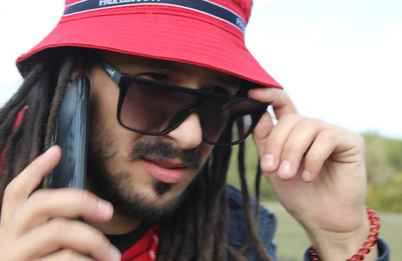 a man with dreadlocks talking on a cell phone