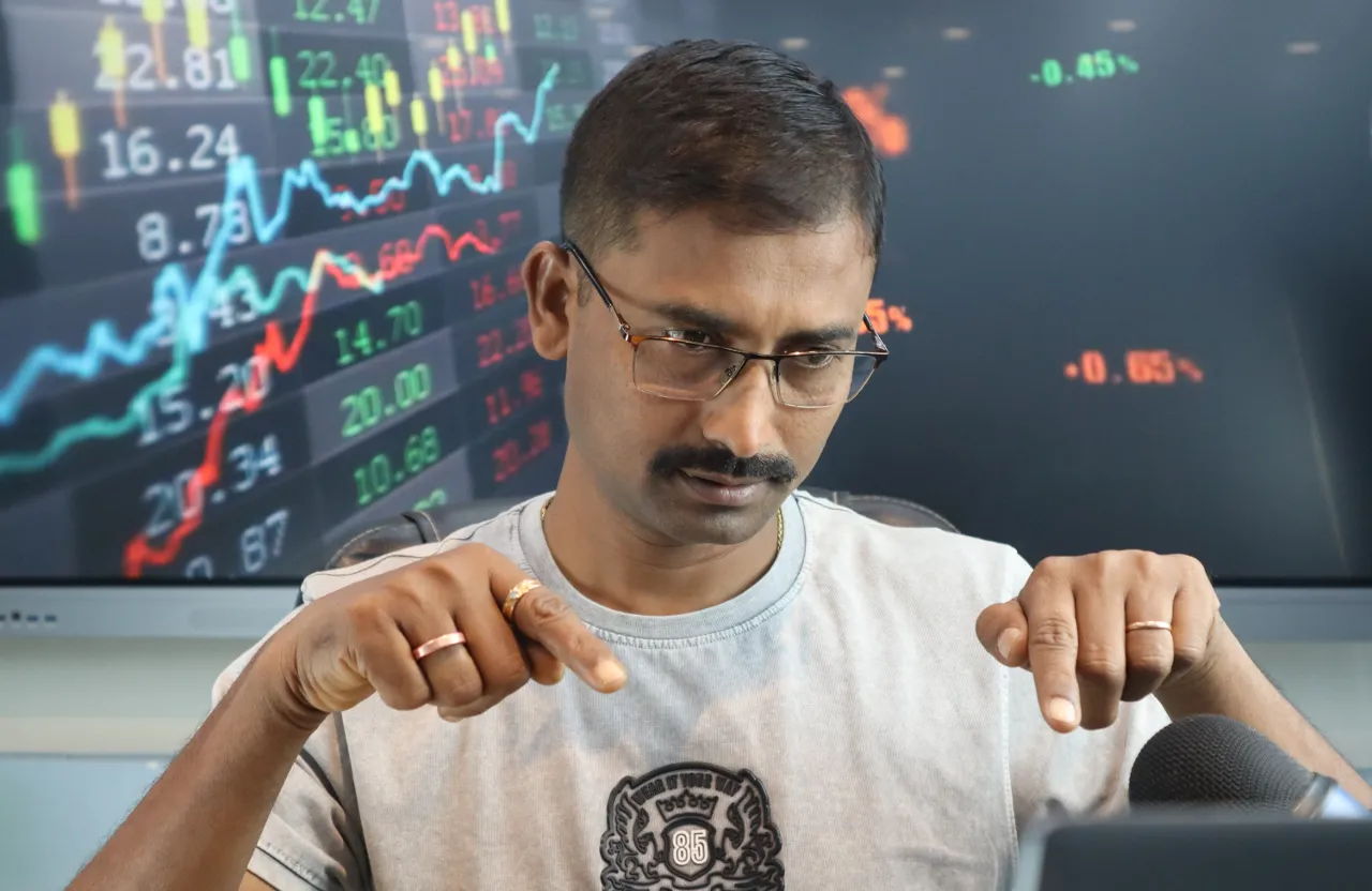 a man in glasses pointing at a laptop screen