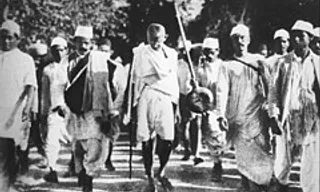 a group of men walking down a dirt road