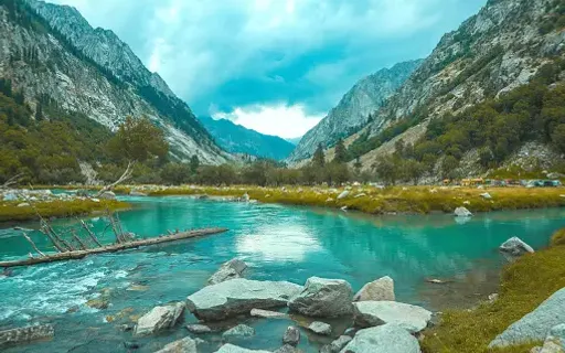 a river running through a valley surrounded by mountains