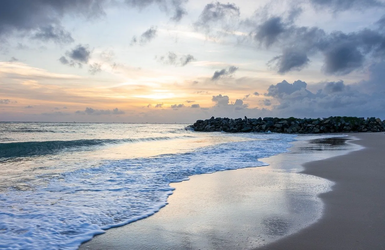 a sandy beach with waves coming in to the shore