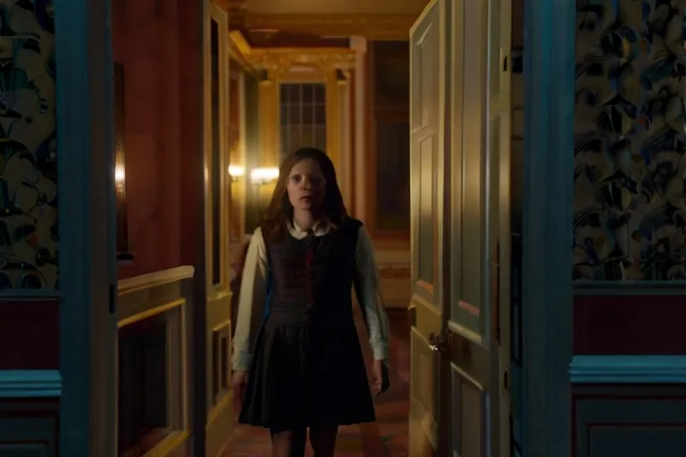 a girl in a dress walking down a hallway