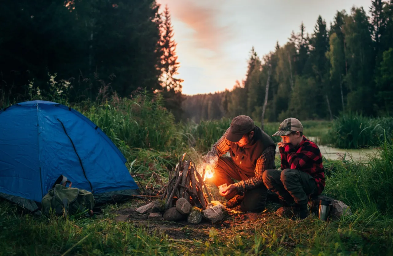 a couple of people sitting around a campfire