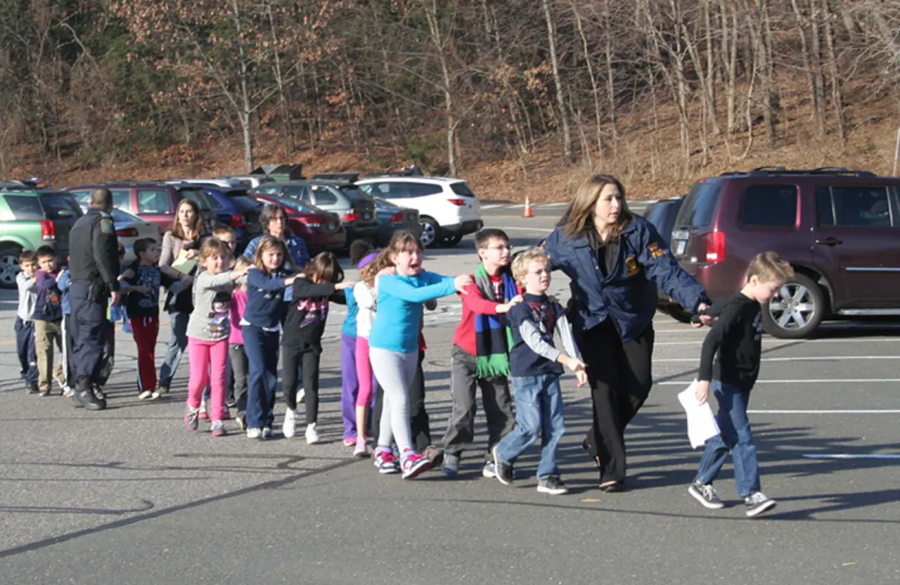 a group of children and adults standing in a parking lot