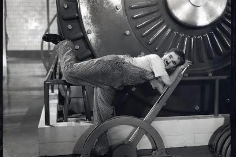 a  fatman  laying on top of a machine, moves it