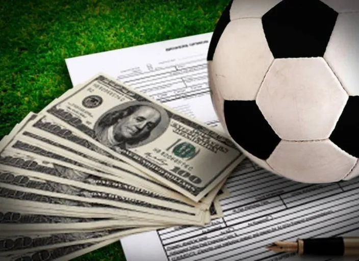 a soccer ball sitting on top of a pile of money