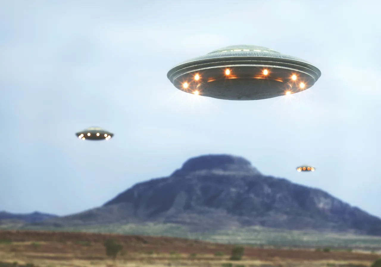 a group of flying saucers over a mountain