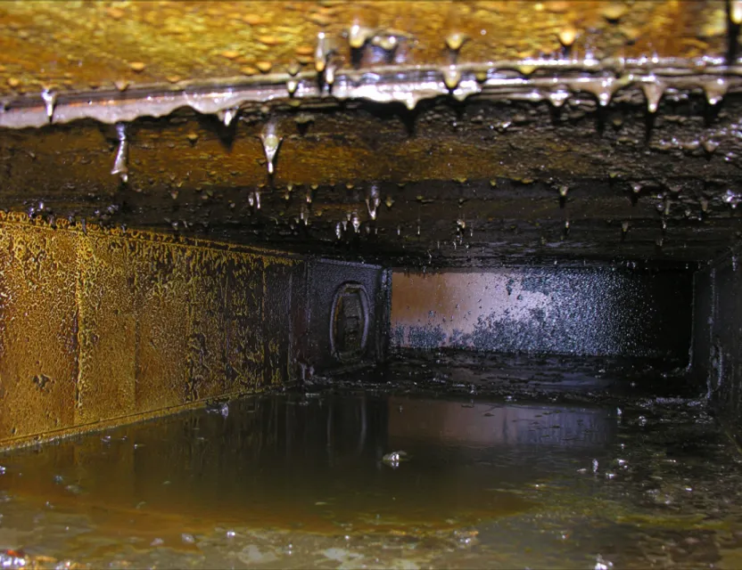 Close-up of the inside of the duct, a large accumulation of fat and oil deposits, grease and oil dripping from the walls of the duct