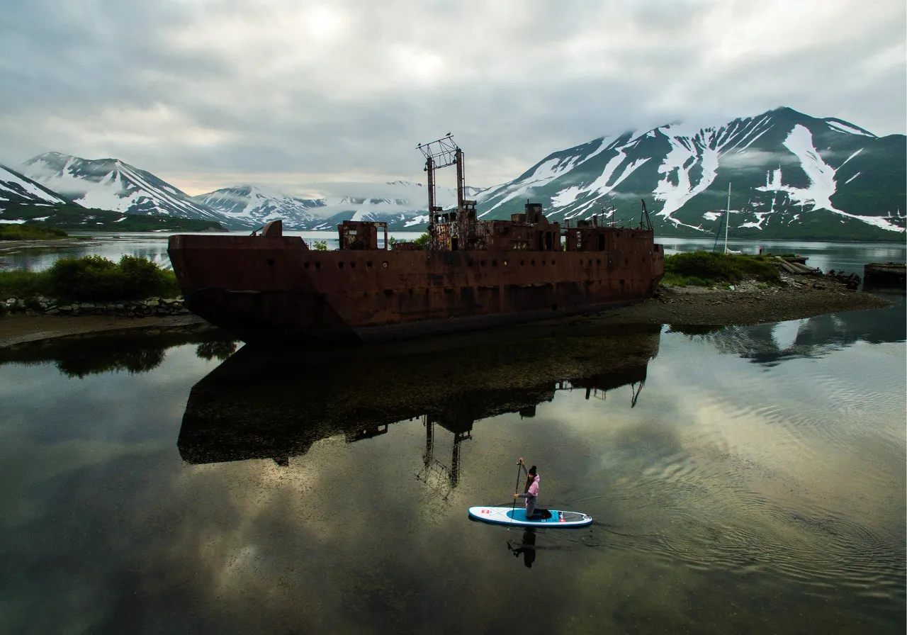 a person standing on a surfboard in a body of water