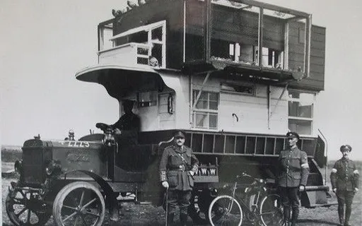 a black and white photo of men standing in front of a truck