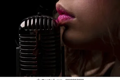 a close up of dark skinned woman singing slowly into a microphone under heavy rain