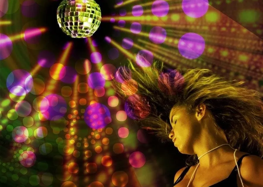 a woman is dancing in front of a disco ball