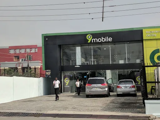 a man standing in  front of a car dealership, walking, green-themed