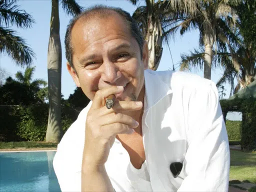 a man sitting in front of a pool smoking a cigarette