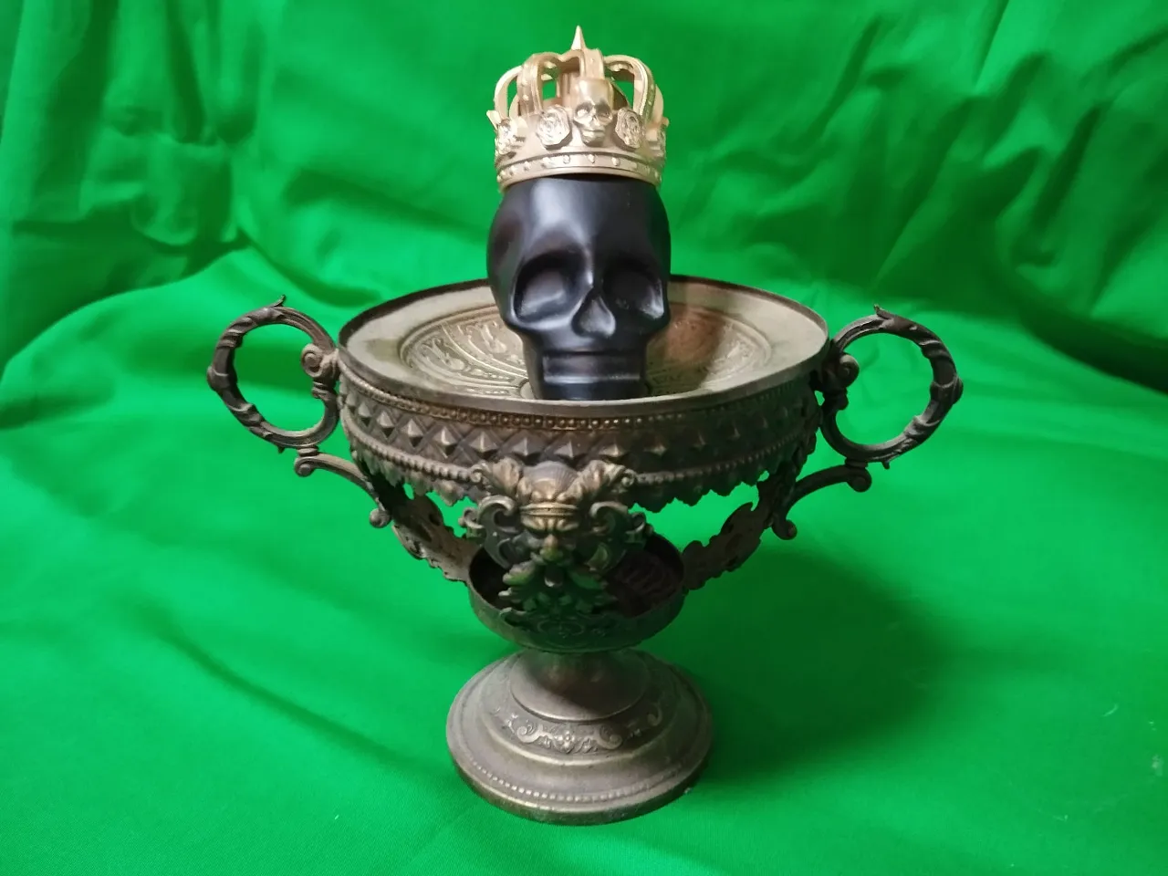 a skull in a crown on top of a vase