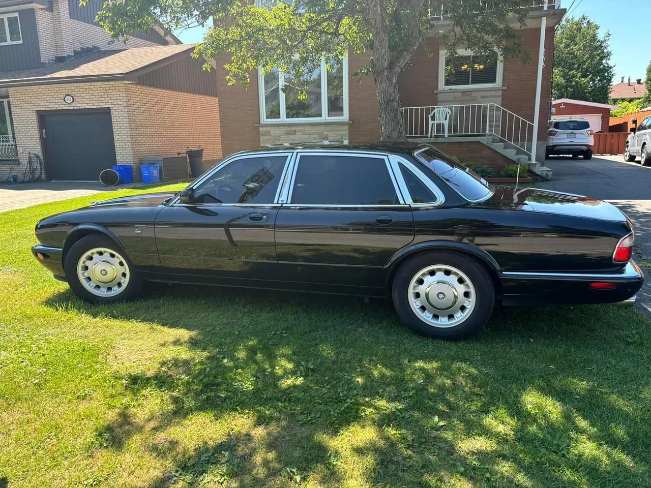 this is a 1999 Jaguar XJ8, have it drive down a long winding road and park right in the middle of a parking lot with all other types of jaguars. , advertising style