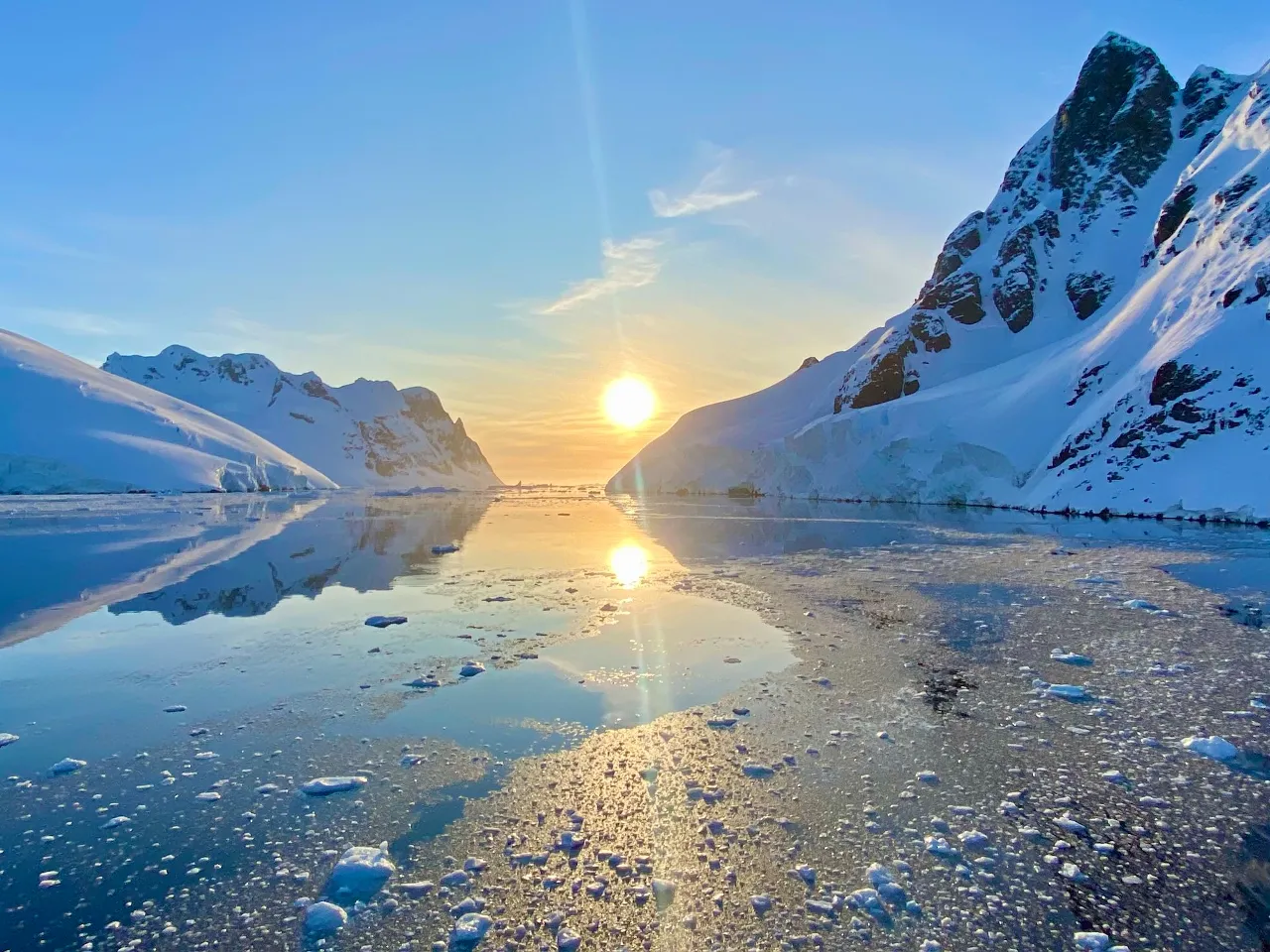 the sun is setting over a mountain lake