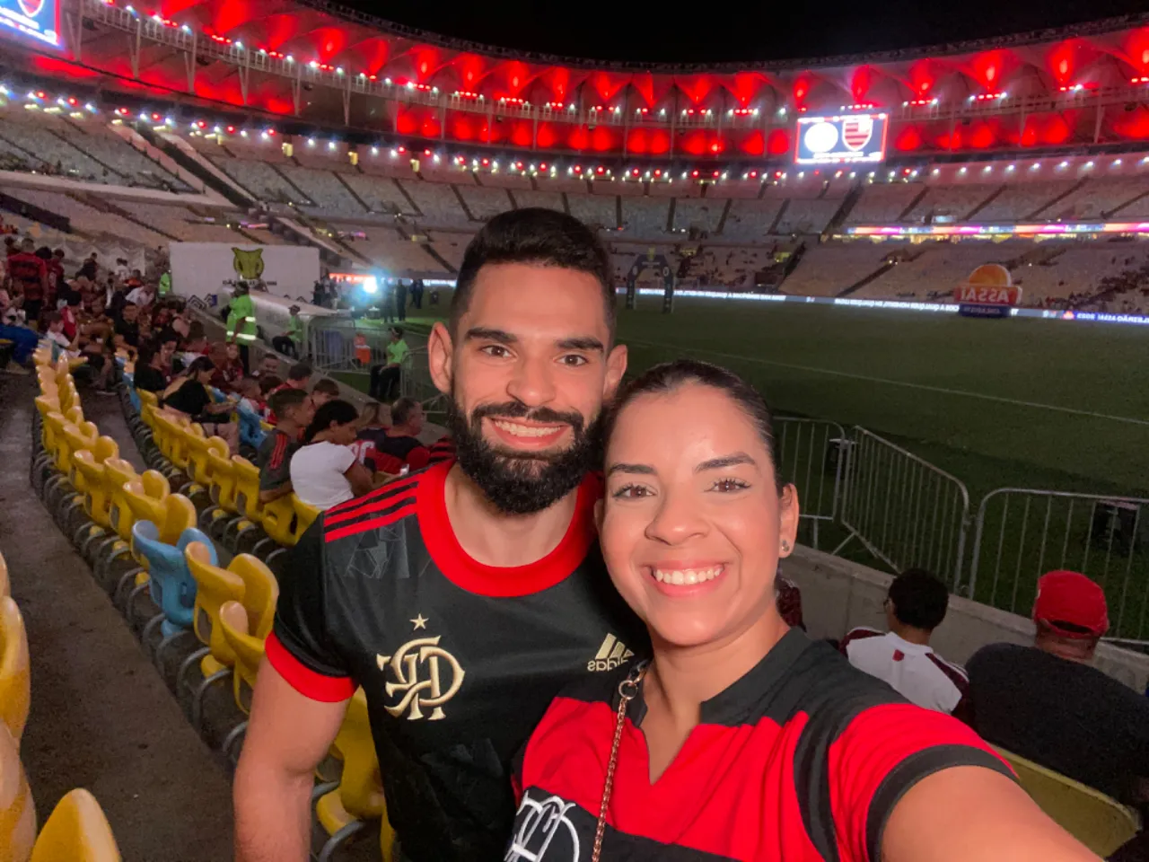 a man and woman taking a selfie at a soccer game