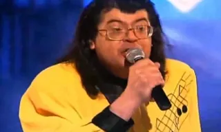 a man in a yellow shirt holding a microphone