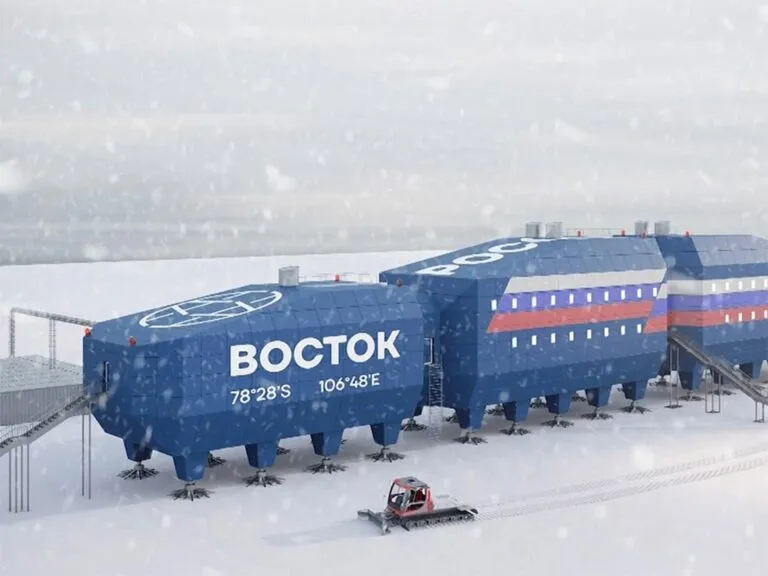 a large blue train car sitting on top of a snow covered field