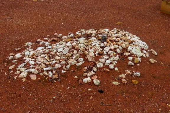 a pile of rocks sitting on top of a dirt field