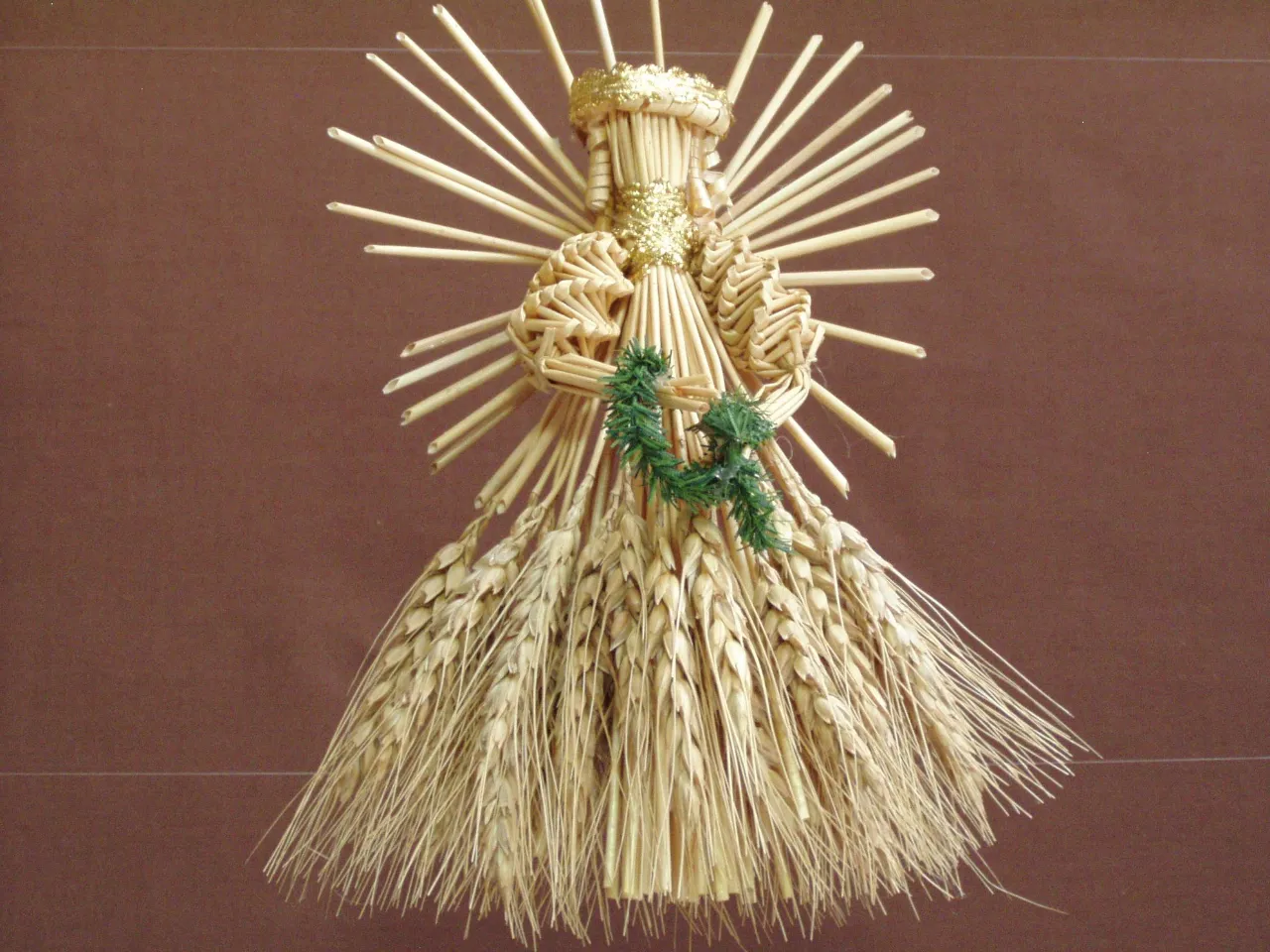 a statue made out of straw with a wreath on top of it